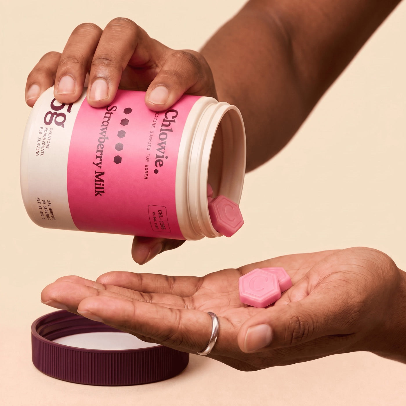 Pouring Chlowie creatine gummies into a hand